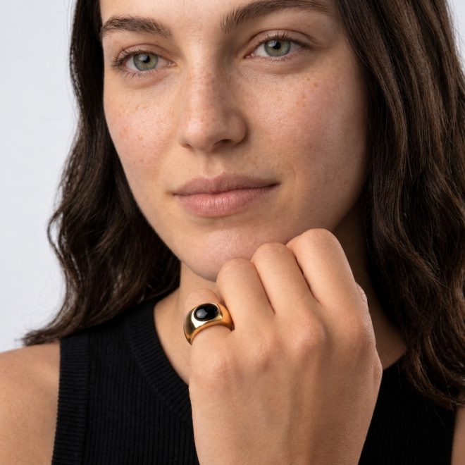 Mujer con anillo en el meñique con piedra negra
