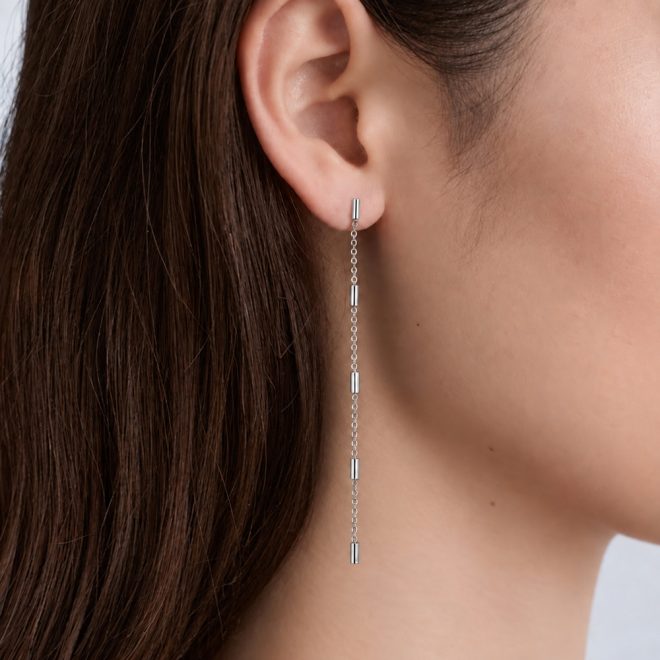 Mujer con pendientes largos de cadenas fina